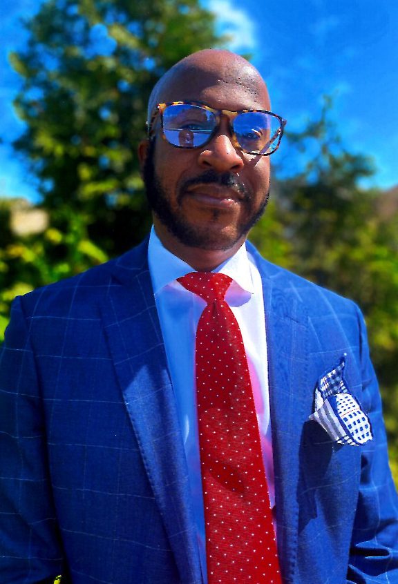 A man in a blue suit and red tie.