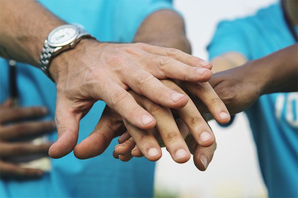 A group of people with their hands together.