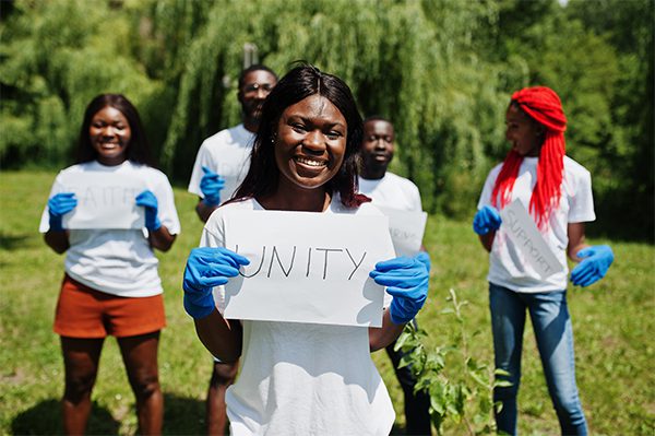 A group of people holding up signs in the grass.